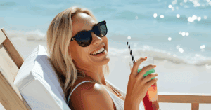 Woman relaxing on beach with cocktail