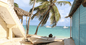 view of the ociean in bavaro beach between buildings with a fishing boat on the shore