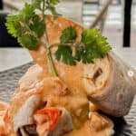 Bayou Burrito with creamy sauce and cilantro garnish.
