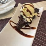 Chocolate cake with vanilla ice cream and syrup.
