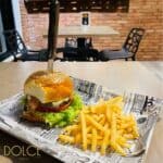 Burger with knife and fries on newspaper tray.