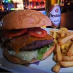 Cheeseburger with fries and beer on table