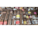 Variety of cigars with flavored labels on shelf.