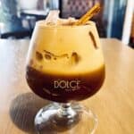 Iced coffee cocktail with cinnamon sticks in glass.