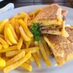Cuban sandwich with fries on white plate
