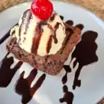 Brownie with ice cream and chocolate drizzle.