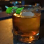 Whiskey glass with ice and lime garnish