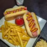 Hot dogs and fries with ketchup and mustard.