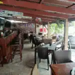Rustic outdoor café with wooden tables and chairs.
