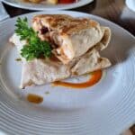 Grilled wrap and fries on plate with garnish