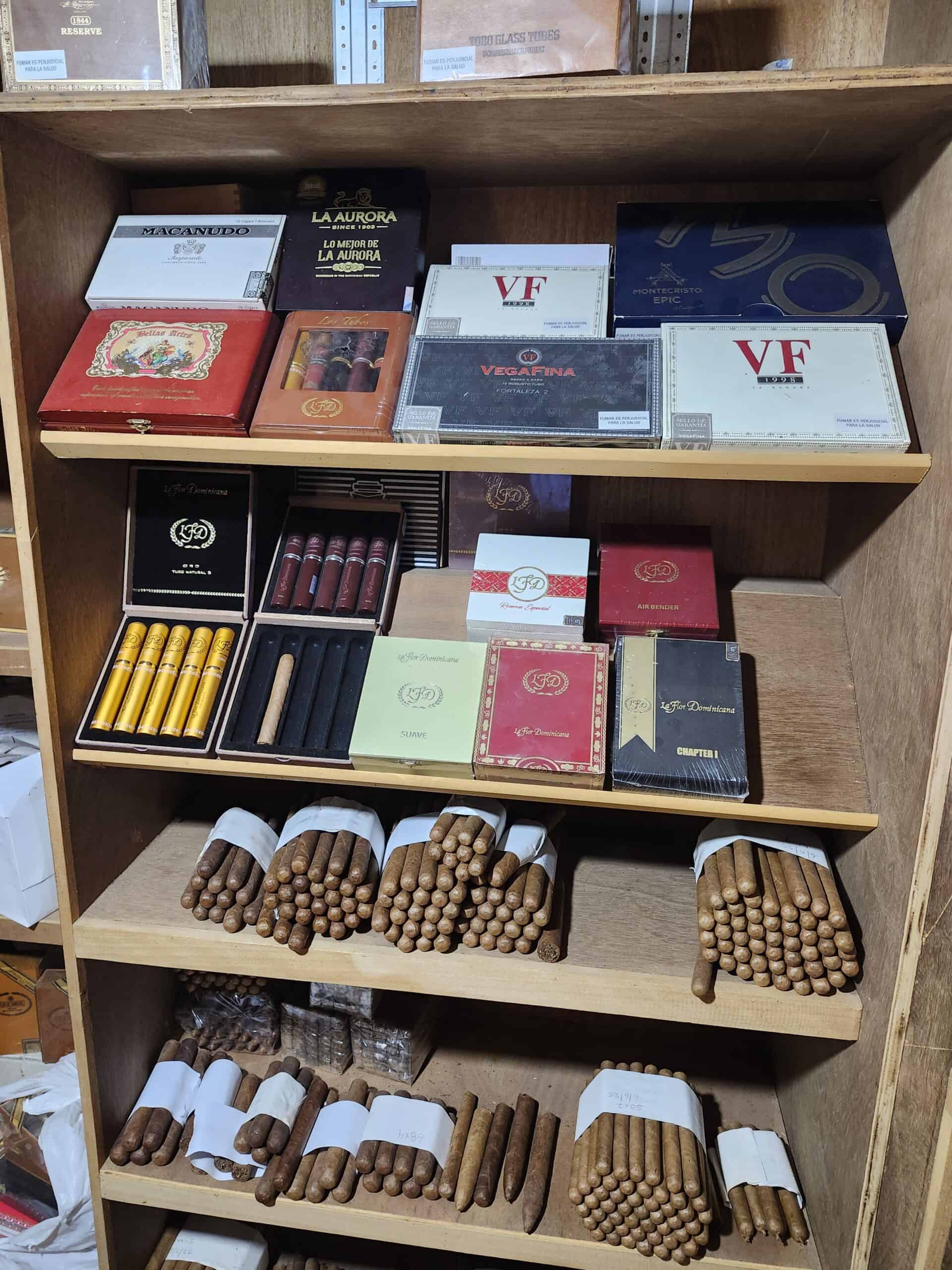 Wooden shelf with boxes and bundles of cigars.