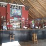 Outdoor bar with TV and shelves of drinks.