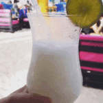 Tropical cocktail on beach with lime slice