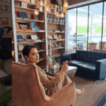 Woman enjoys coffee in cozy bookstore cafe.