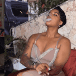 Person enjoying a cigar outdoors, evening setting.
