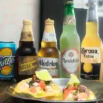 Mexican beers and shrimp tacos on a plate