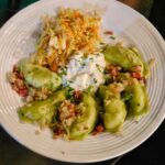 Plate of dumplings with sauerkraut and sour cream.