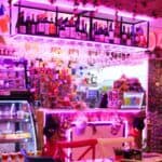 Colorful bar with wine bottles and neon lights.