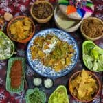 Mexican meal with nachos, meats, salsas, and limes.
