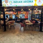 Indian Aroma restaurant entrance with tables and decor.