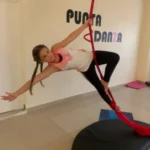 Girl practicing aerial silks in dance studio.