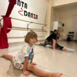 Children practicing splits in dance studio.